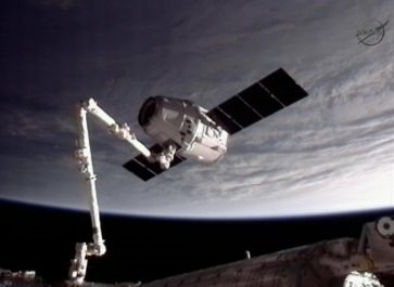 La navicella spaziale SpaceX Dragon catturata dal braccio robotico della Stazione Spaziale Internazionale La navicella spaziale SpaceX Dragon catturata dal braccio robotico della Stazione Spaziale Internazionale (Foto NASA TV)