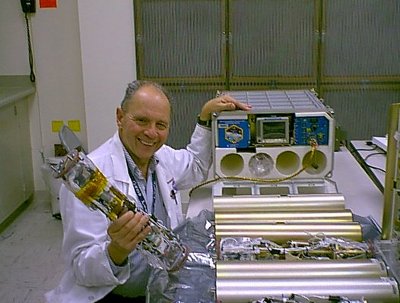 Il Dottor Dennis Morrison assieme al Microencapsulation Electrostatic Processing System usato sulla Stazione Spaziale Internazionale (Foto NASA)